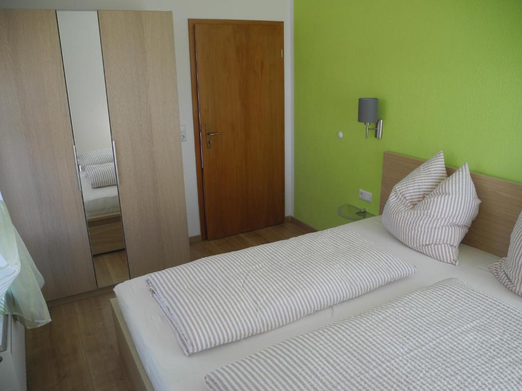 魏森贝格Ferienwohnung Wünsche的白色的床,位于带绿色墙壁的房间