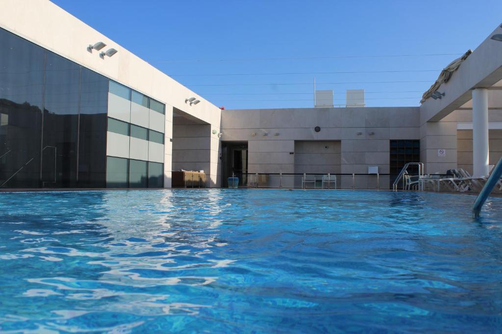 荷兹利亚First Class Marina Herzlia的大楼前的游泳池