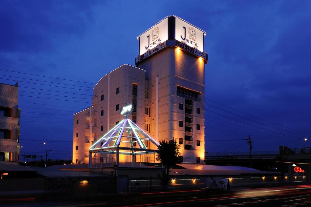 小牧市喜悦情趣酒店（仅限成人）的一座建筑的顶部有一个钟楼