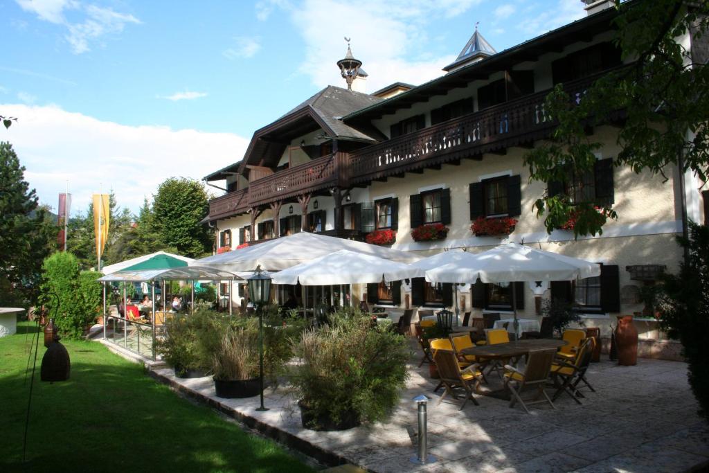 施特罗布尔斯特伦布勒霍夫酒店的前面有桌子和伞的建筑