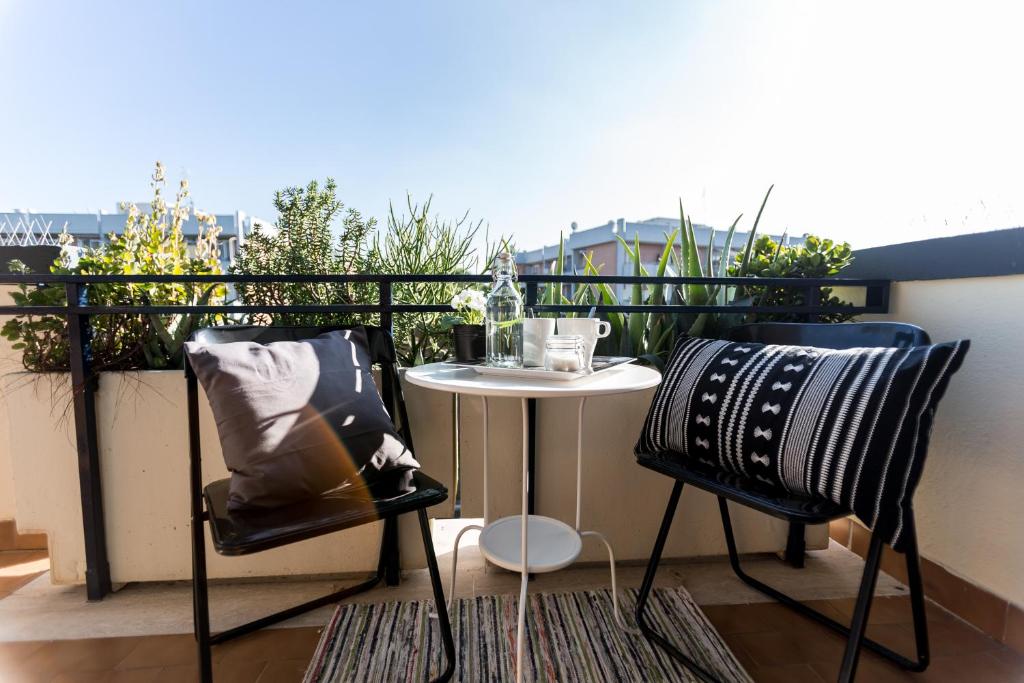 罗马Casa Giordano的阳台配有一张小桌子和两把椅子