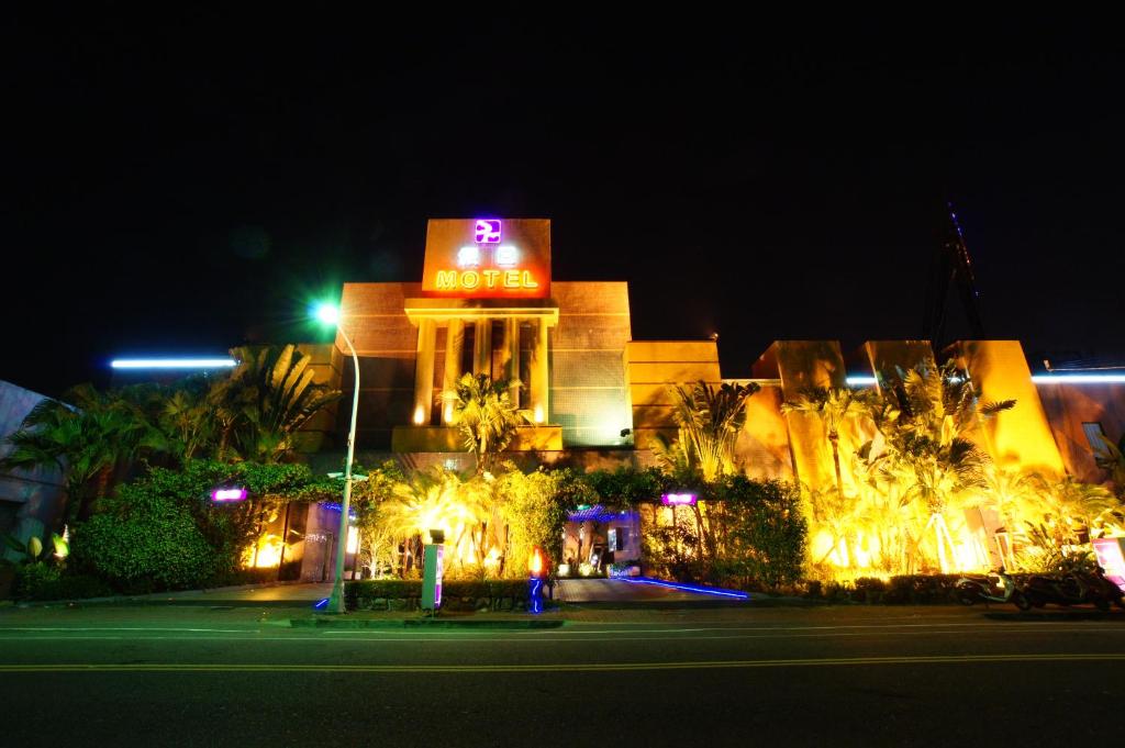 台南Holiday Motel的一座晚上有 ⁇ 虹灯标志的建筑