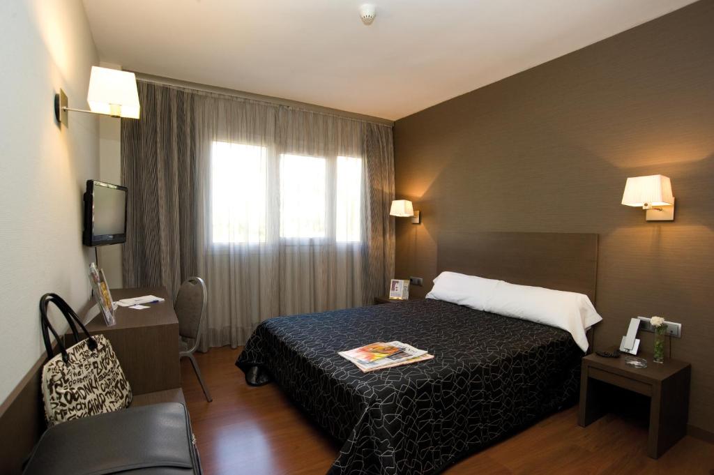 阿尔卡拉德荷那利斯西斯内罗斯酒店的酒店客房设有床和窗户。