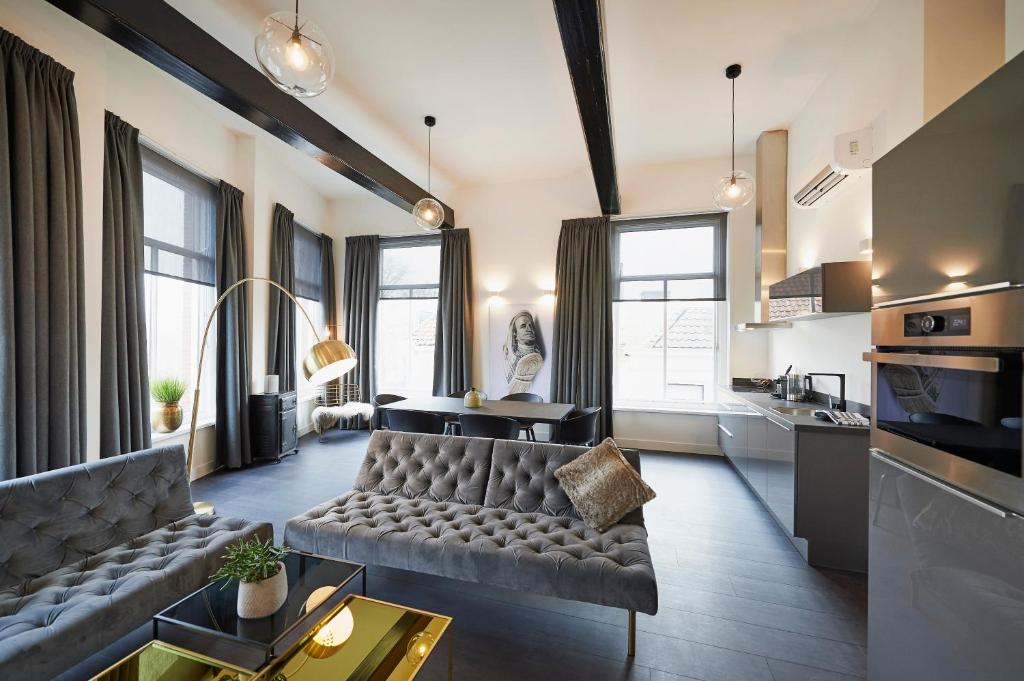 哈林亨"DE BANK" - Hotel Apartments的带沙发的客厅和部分窗户。