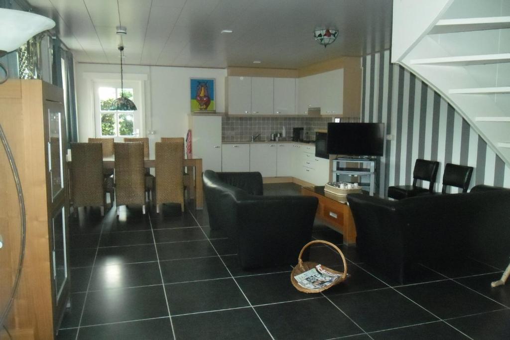 Heeswijk-DintherHerkenhoek 3 bedroom apartement的一间带桌椅的客厅和一间厨房