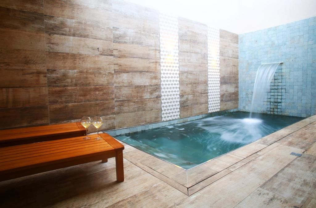 弗洛里亚诺波利斯Zaya Motel Premium的热水浴池、长凳和喷泉