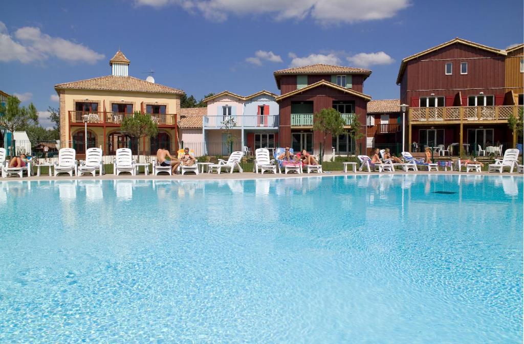 勒泰克玛达姆瓦康斯 - 列维玛琳酒店的一个带椅子的大型游泳池,人们坐在椅子上