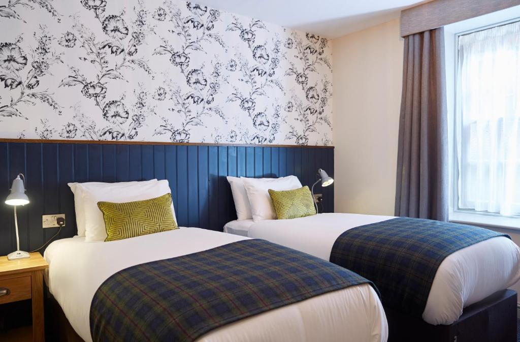 奥尔顿Swan Hotel by Greene King Inns的酒店客房设有两张床和窗户。