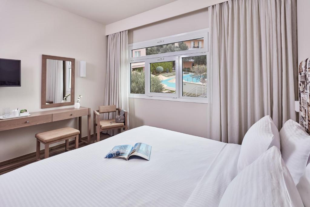 雅典爱斯普瑞希维特尔酒店的配有一张床、一张书桌和一扇窗户的酒店客房