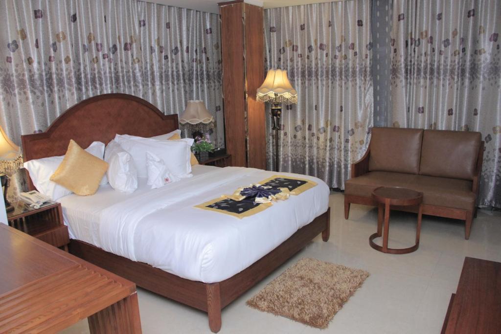 达累斯萨拉姆Zimbo Golden Hotel的配有一张床和一把椅子的酒店客房