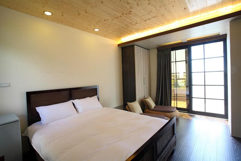 吉安松町的卧室设有一张白色大床和一扇窗户。