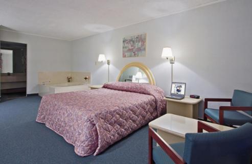 BishopvilleAmericas Best Value Inn - Bishopville的一间卧室配有一张大床和粉红色的床罩