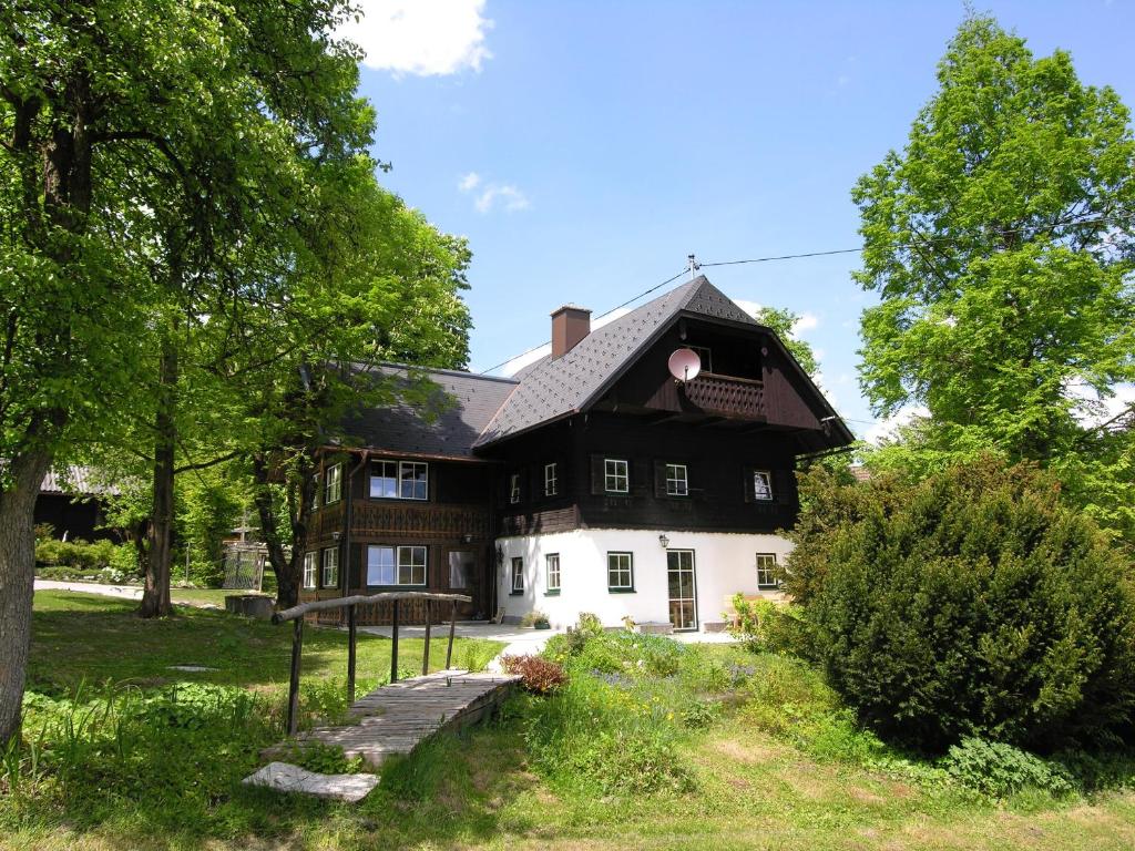 巴德哥依斯恩Ferienhaus Gut - Eisenlehen的黑白的房屋,有树木和草地