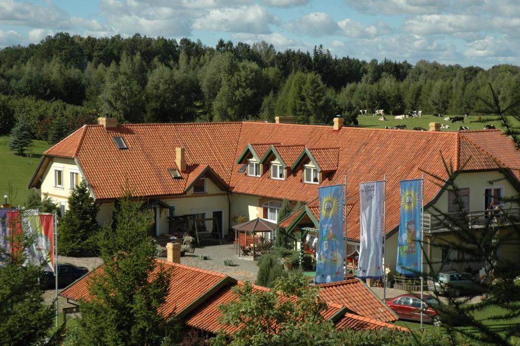 奥莱茨科Majątek Giże Marczak的一座带红色瓦屋顶和庭院的大型建筑