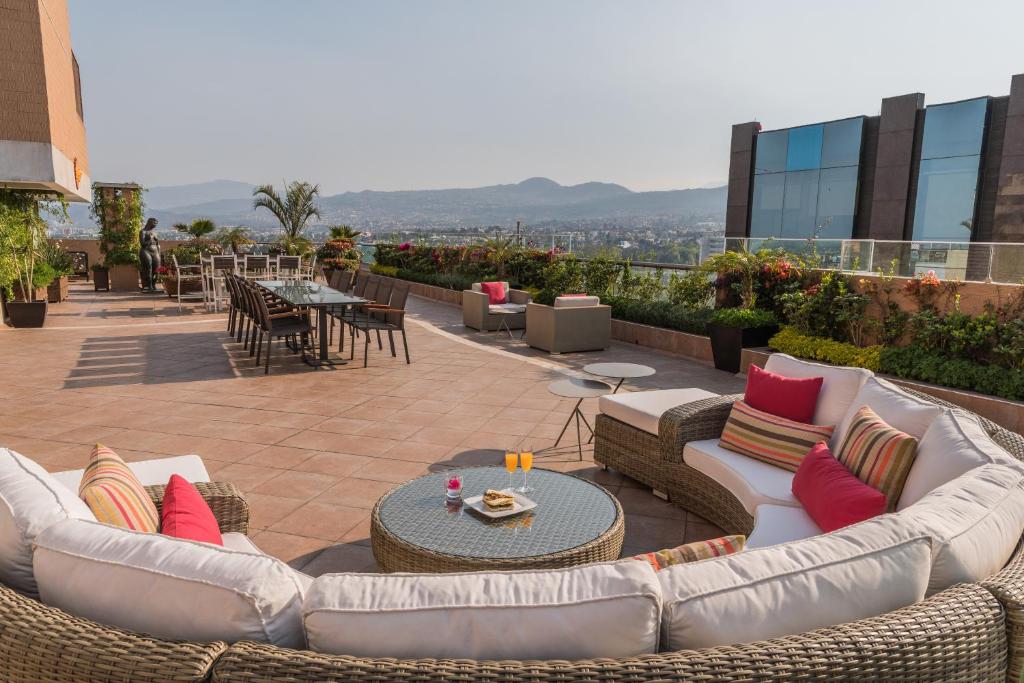 墨西哥城阿姆布拉多斯佩里苏尔套房酒店的屋顶上带沙发和桌子的庭院