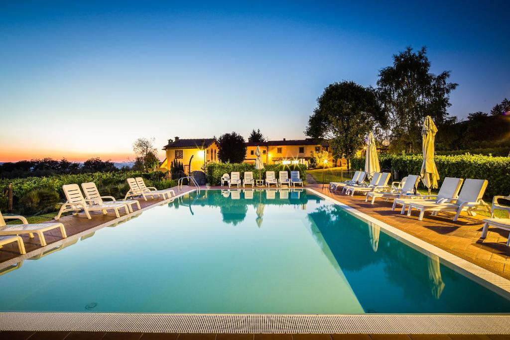 雷杰洛Agriturismo San Jacopo的一个带躺椅的游泳池,一个度假村