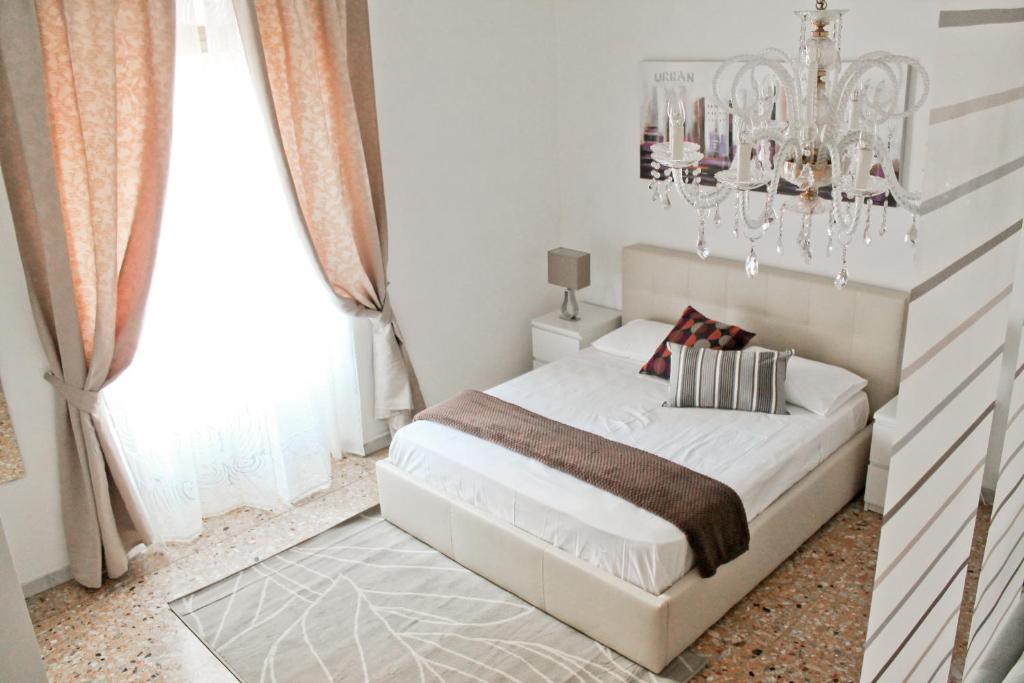 罗马Nonna grazia的卧室配有白色的床和吊灯。