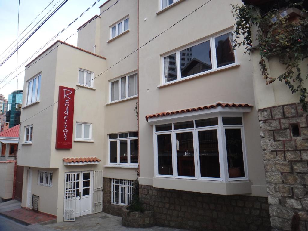 拉巴斯Rendezvous Hostal的一面有红色标志的建筑物