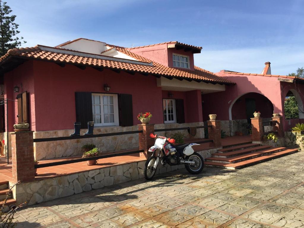 奥古斯塔Villa Angela的停在红房子前面的摩托车