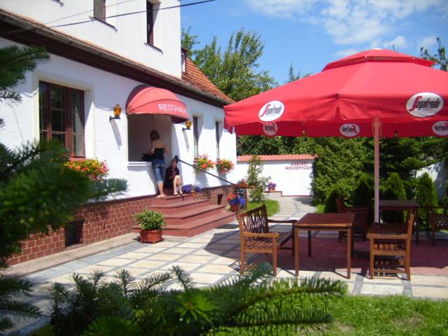 斯武普斯克扎亚兹德比亚里多姆宾馆的一个带桌子和两把红色遮阳伞的庭院