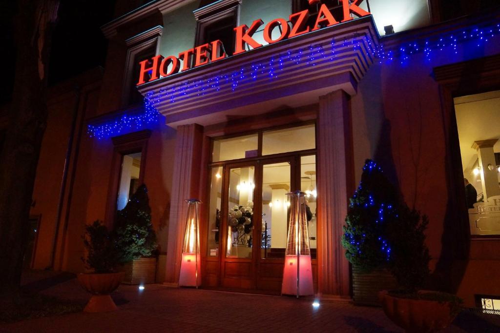 海乌姆Hotel Kozak的门上方标有 ⁇ 虹灯的酒店