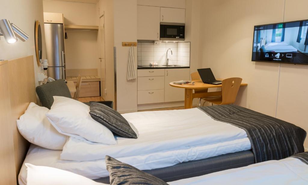 林雪平林雪平城市酒店与青年旅舍的一间卧室配有一张床,厨房配有电视