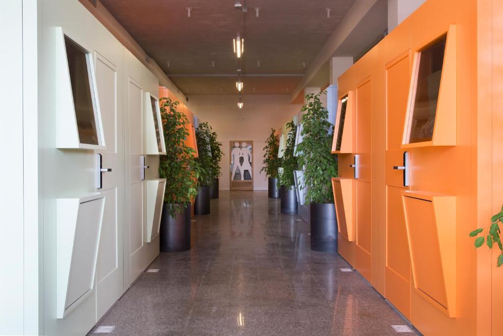 那不勒斯住宿用餐胶囊旅馆的办公室楼内带有盆栽的走廊