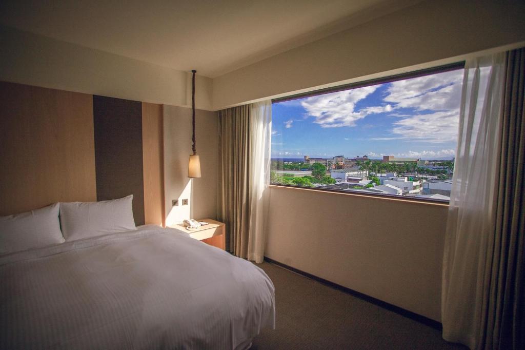 台东台东南丰铁花栈的酒店客房设有一张床和一个大窗户