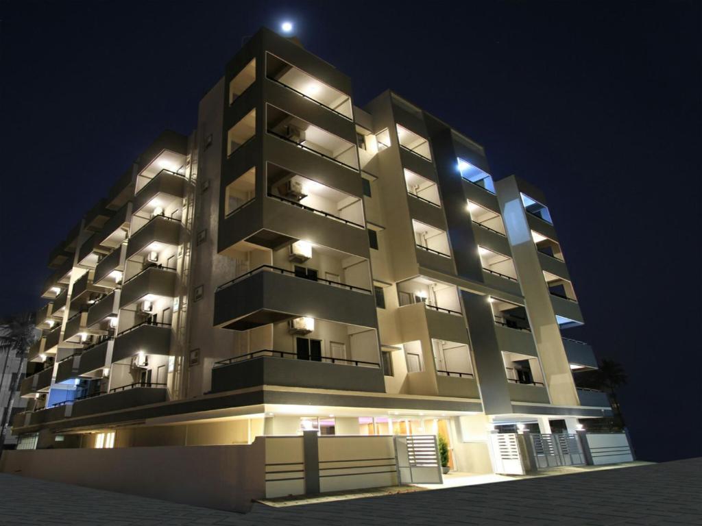 德瓦纳哈利-班加罗尔Arra Grande Suites - Nearest Airport Hotels Bangalore的一座大型公寓楼,晚上有灯
