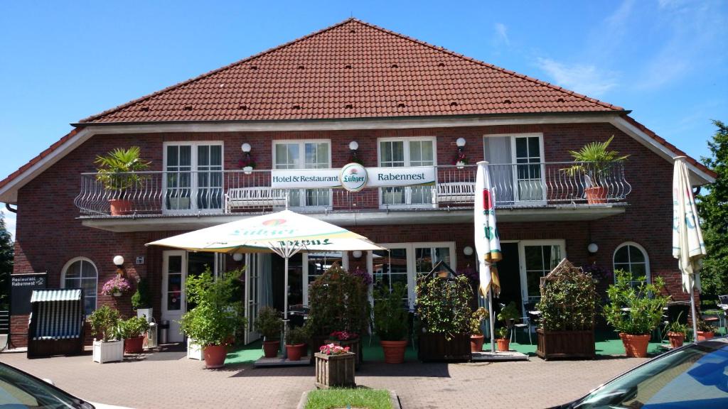 Raben SteinfeldHotel und Restaurant Rabennest am Schweriner See的一座建筑前面有雨伞和植物