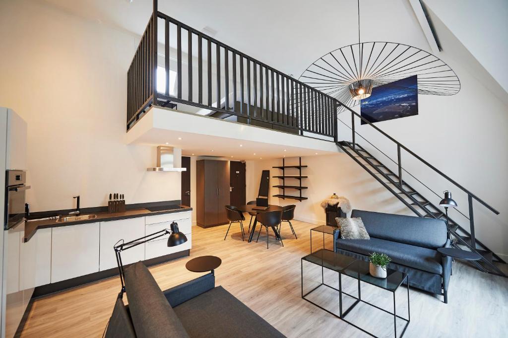 哈林亨"DE BANK" - Hotel Apartments的客厅设有蓝色的沙发和楼梯。