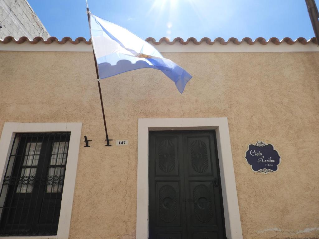 乌玛瓦卡切洛阿里巴度假屋的悬挂在大楼前的旗帜,有门