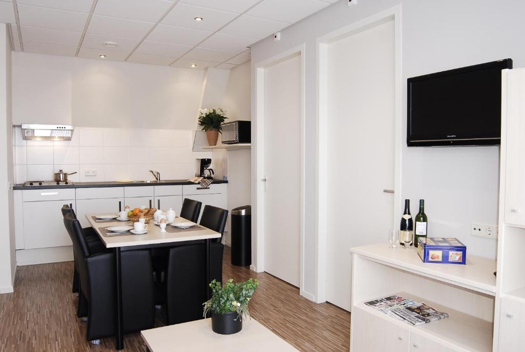 阿赫特克克Kodde Apartments的厨房以及带桌椅的用餐室。