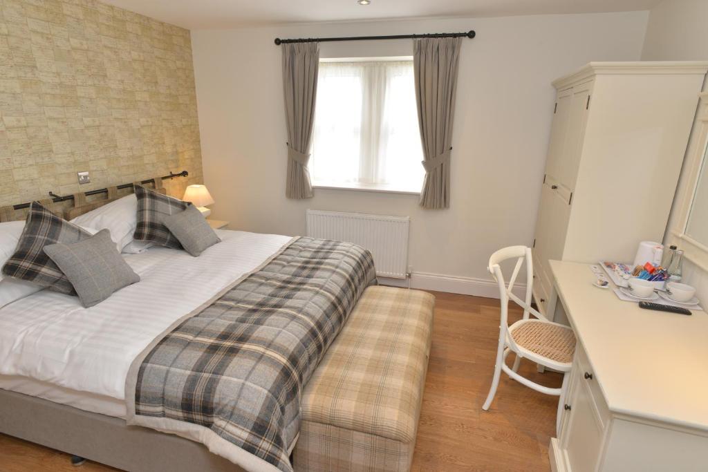 斯基普顿长毛羊宾馆的一间卧室配有一张带书桌的床和窗户。