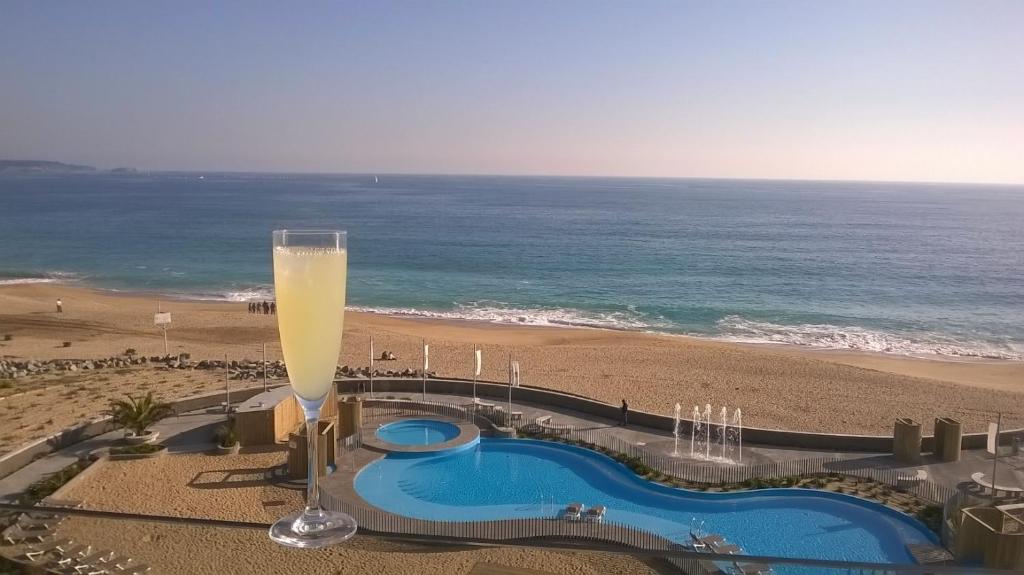 阿尔加罗沃Apartamentos Arenamaris的海滩旁一杯高大的香槟