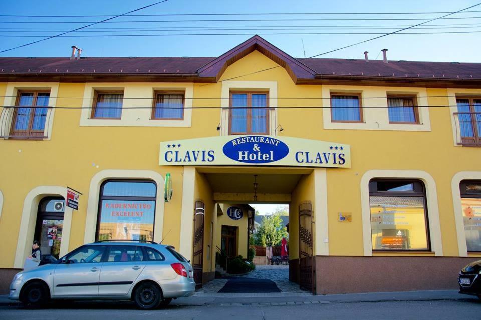 卢切内茨Hotel Clavis的停在黄色建筑前面的汽车