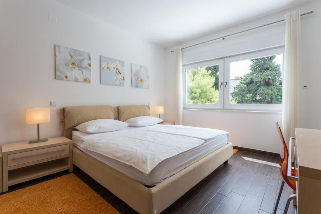 杜布罗夫尼克Apartments Villa Alba的白色的卧室设有床和窗户