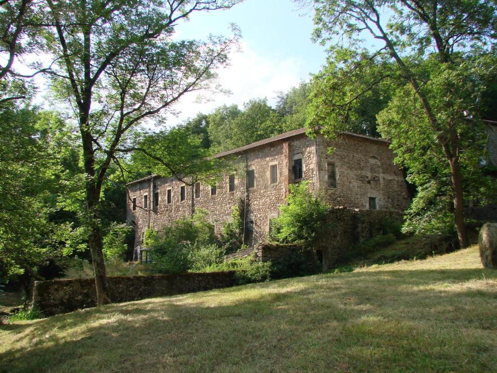 Vernoux-en-VivaraisThe lodges of Monepiat的田野中间的一座古老的石头建筑