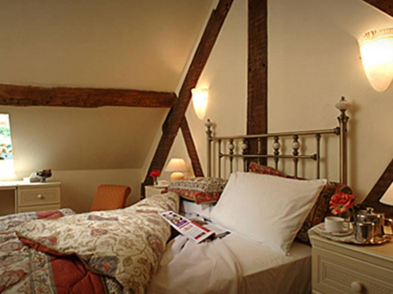 马奇温洛克盖斯凯尔阿姆斯酒店的一间卧室配有一张床和一张带台灯的书桌