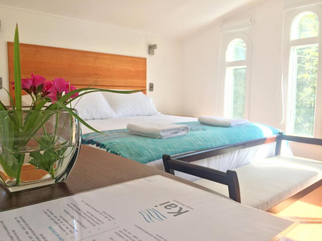 阿尔加罗沃Kai Bed and Breakfast的一间卧室设有两张床和一张花瓶桌子。