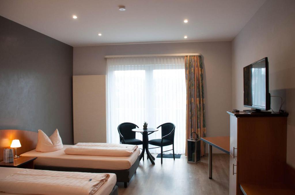 皮特林根皮特林根斯塔德特酒店的酒店客房设有两张床、一张桌子和一个窗户。