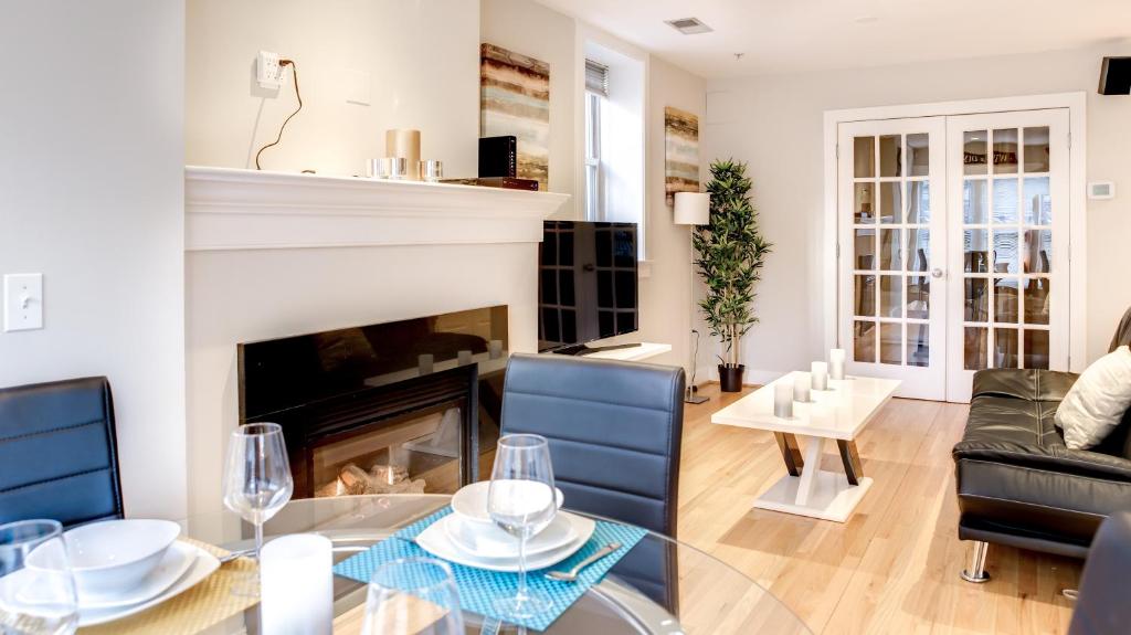 华盛顿Fully Furnished Apartment in Washington near Logan Circle的客厅设有壁炉、桌子和椅子