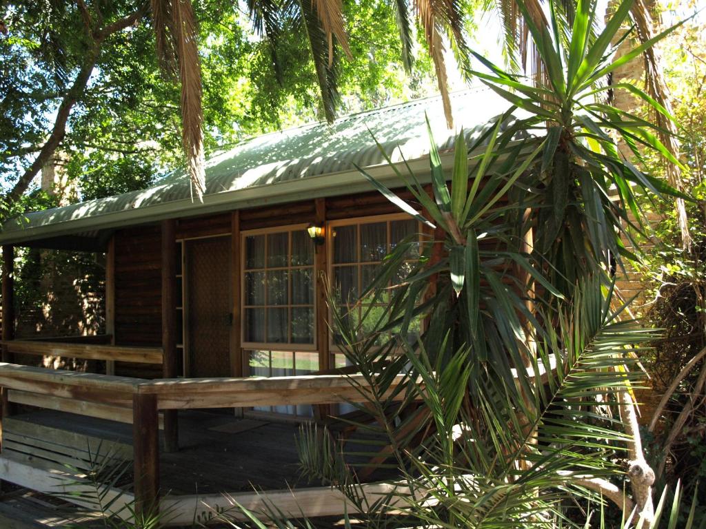格罗夫海洋钛树度假村的树林中的小屋,前面设有长凳