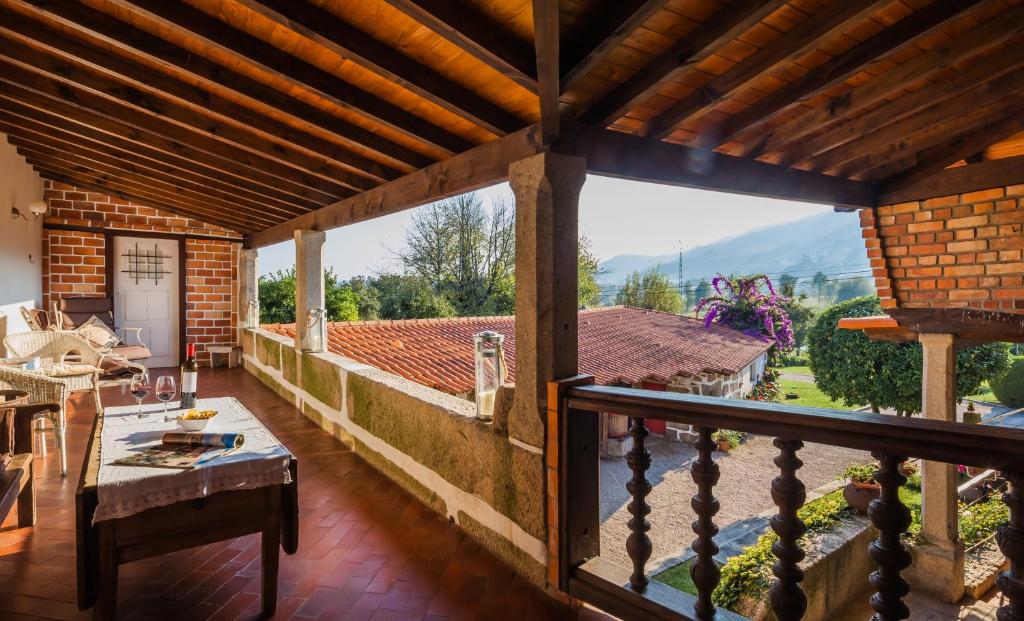 吉马良斯1720 Quinta da Cancela - Winery & Farmhouse的阳台享有房屋美景,配有桌子