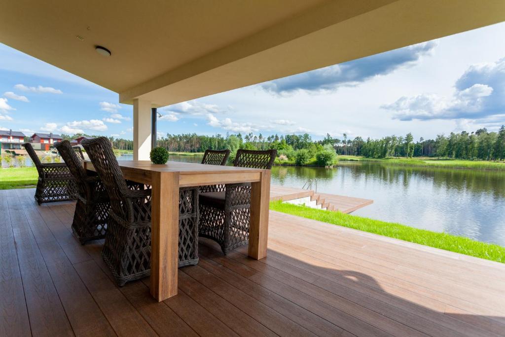 塞尼察GolfBay Villa的湖景门廊配有桌椅