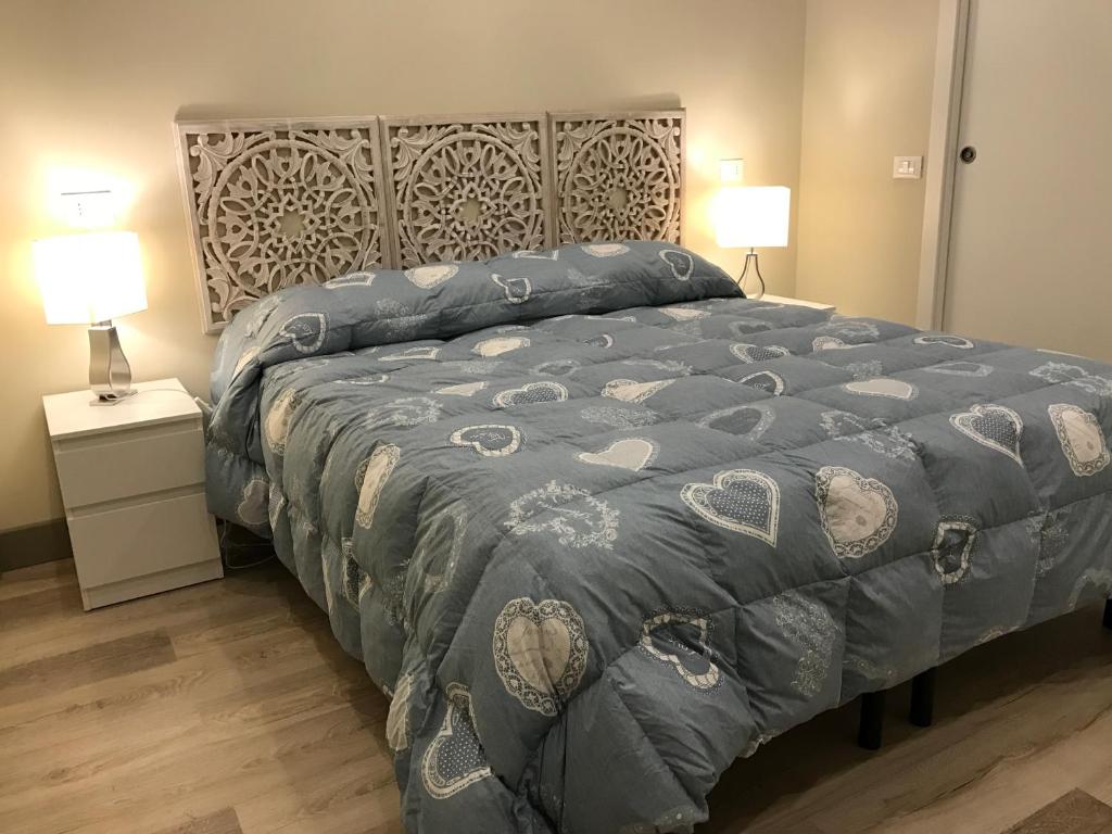 坎波巴索Dimora Spina in centro的一间卧室配有一张带蓝色被子的床和两盏灯。