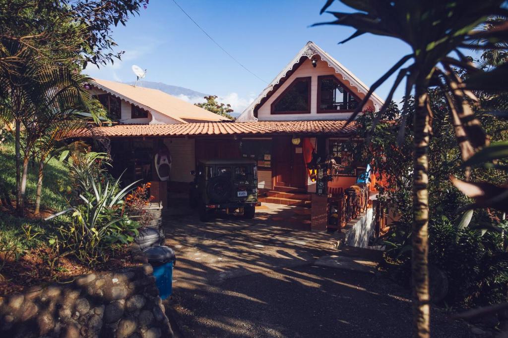 图里亚尔瓦Spanish by the River - Turrialba的前面有棕榈树的房子