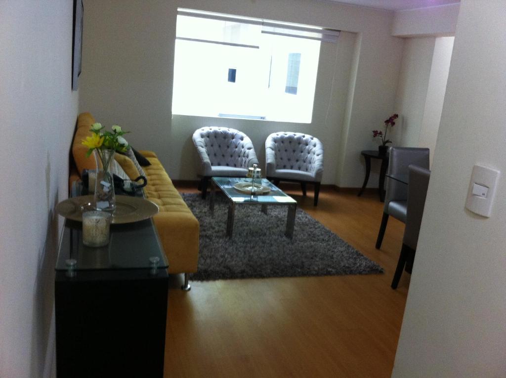 利马Departamento Miraflores的客厅配有沙发和桌椅