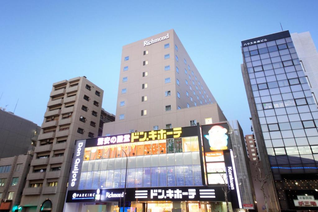 东京里士满东京水道桥酒店的城市里一座高大的建筑,有标志