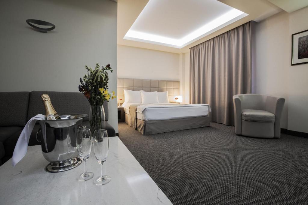 埃里温阿韦亚特斯酒店的酒店客房,配有床和桌子,配以酒杯